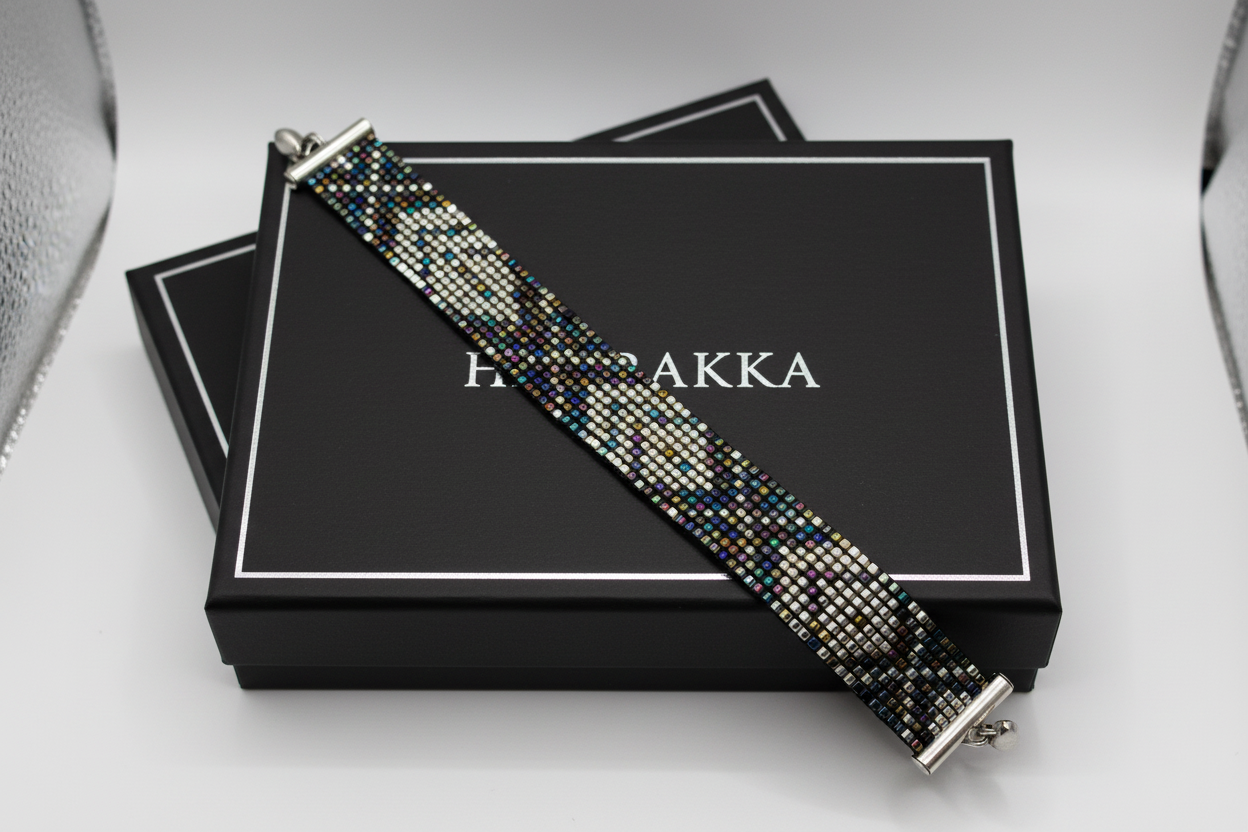 Ručne tkaný náramok Nočný Atlas v tmavých a strieborných tónoch na zápästí

Detail vzoru náramku Nočný Atlas z tmavomodrých, hnedých a strieborných korálikov

Elegantný ručne tkaný náramok Nočný Atlas s magnetickým zapínaním