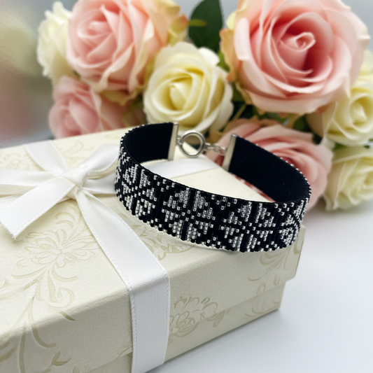Ručne tkaný čierno-strieborný elegantný náramok so vzorom na ženskom zápästí