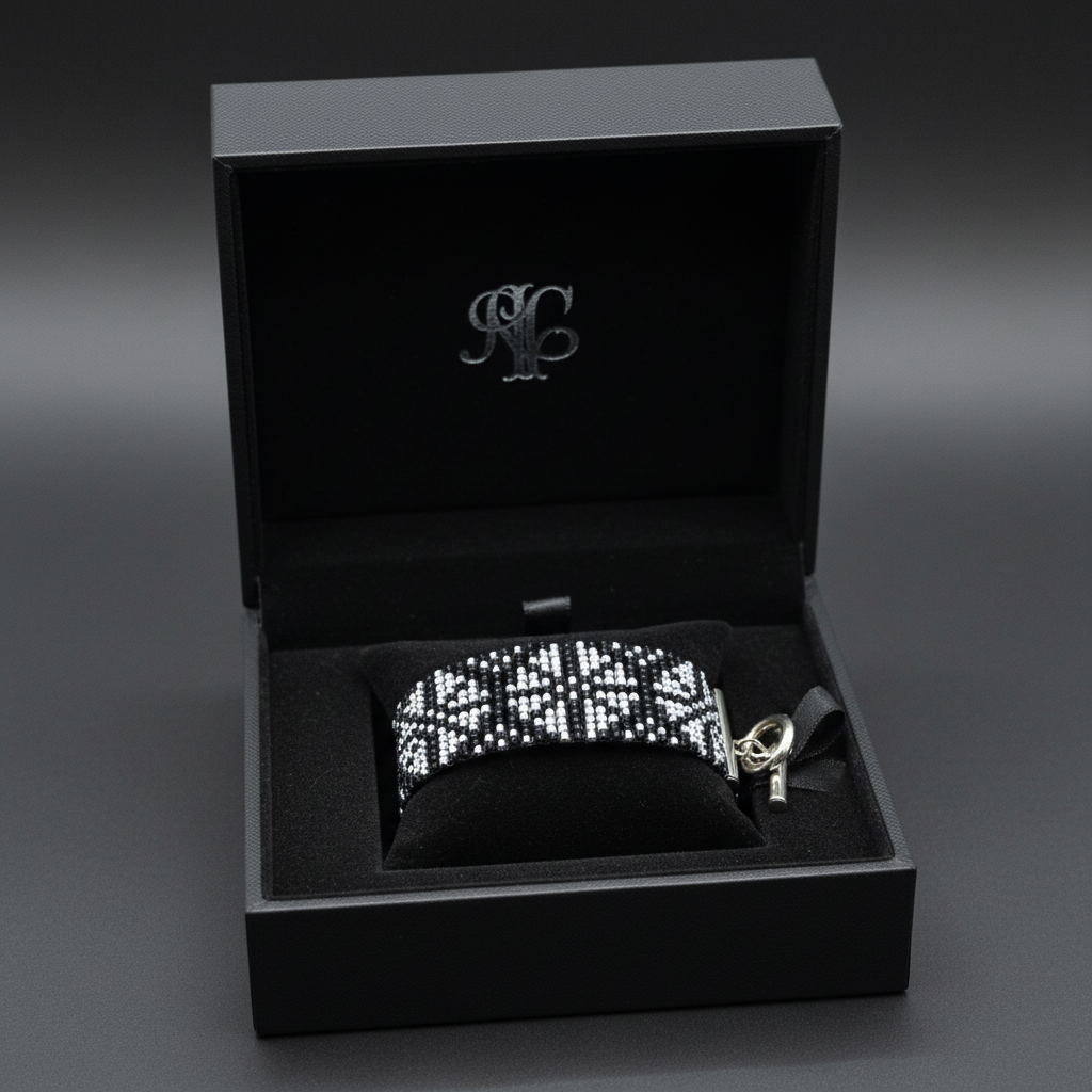 Ručne tkaný čierno-strieborný elegantný náramok so vzorom na ženskom zápästí