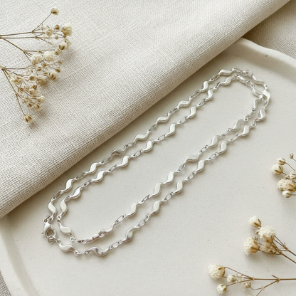 Harakka – Queen Vlnky strieborná retiazka flat lay