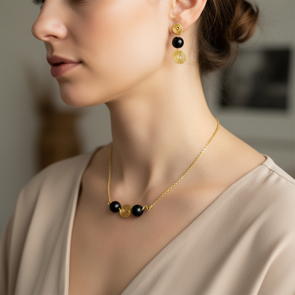 Set náhrdelnika a náušníc s obsidiánom a zlatou špirálou na modelke – Harakka Jewls