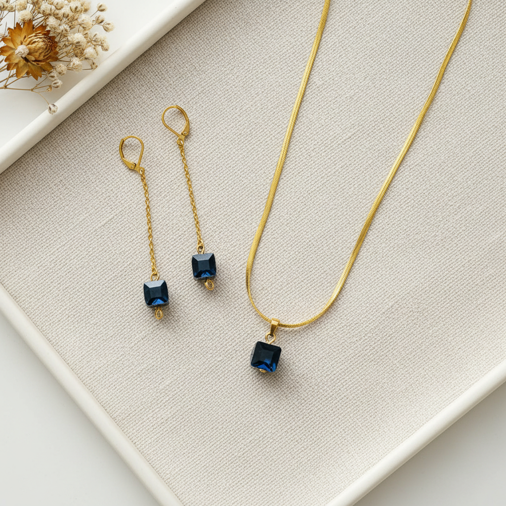 Flat lay set náhrdelnika a náušníc s tmavomodrými kameňmi na ľanovej látke – Harakka Jewls