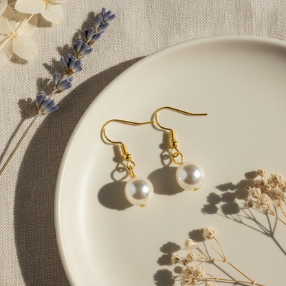Zlaté náušnice s bielou perlou – luxusný flat lay Harakka