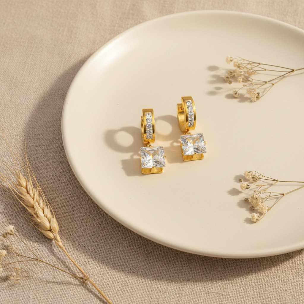 Zlaté náušnice s kockovým zirkónom – luxusný flat lay Harakka