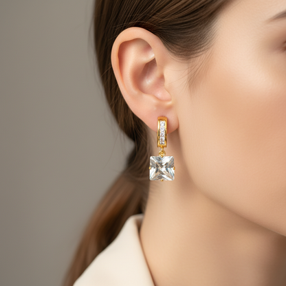 Zlaté náušnice s kockovým zirkónom na modelke – Harakka Jewls