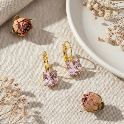 Zlaté náušnice s ružovým zirkónom – luxusný flat lay Harakka